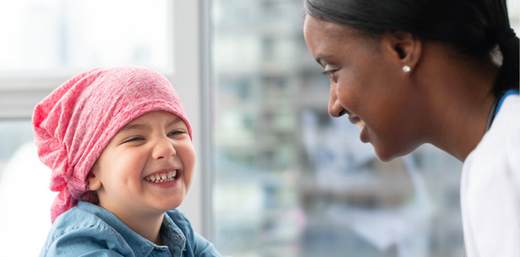 Child in pink head wrap talks to female doctor