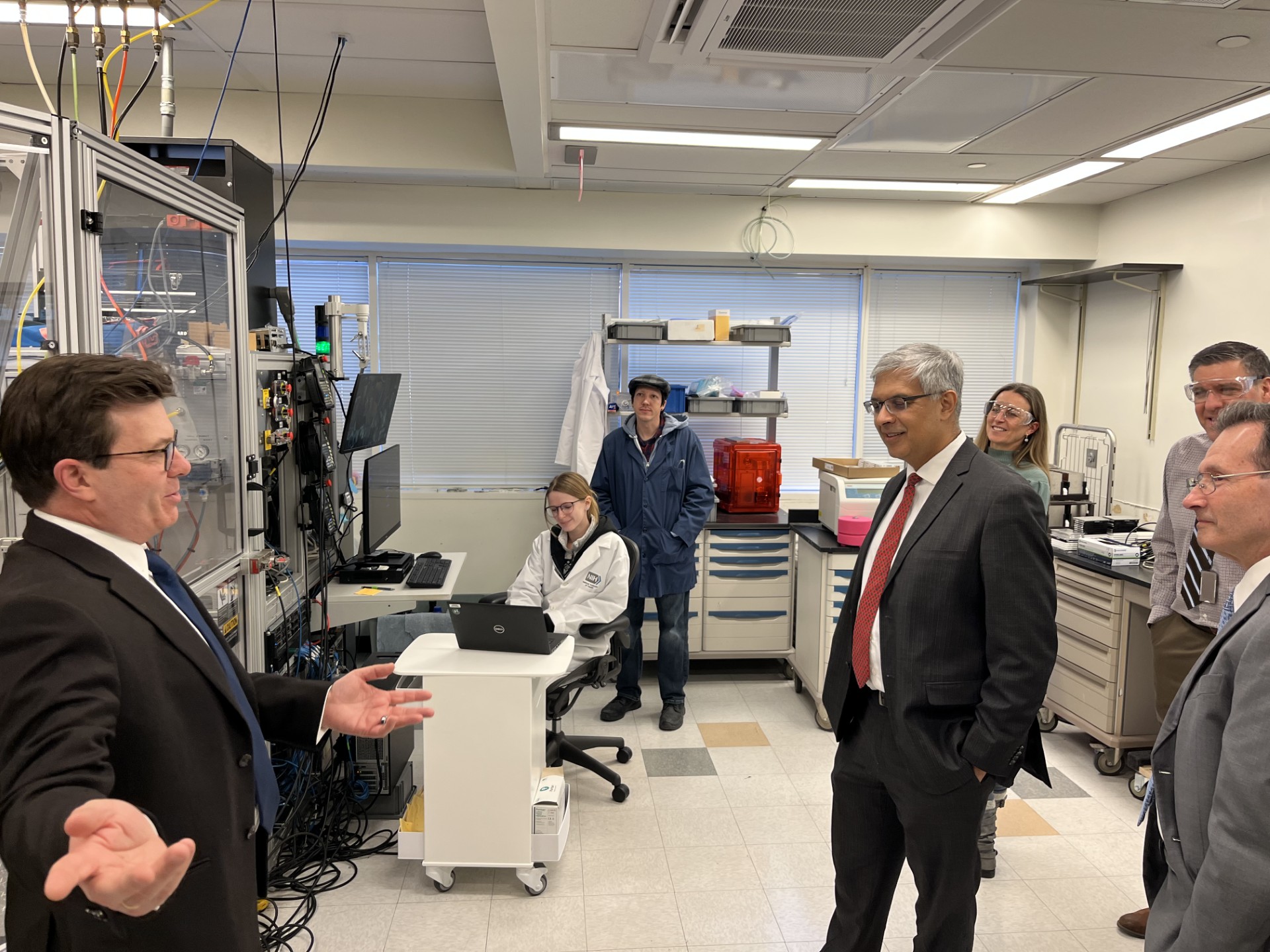 Group of people walking through a laboratory setting.