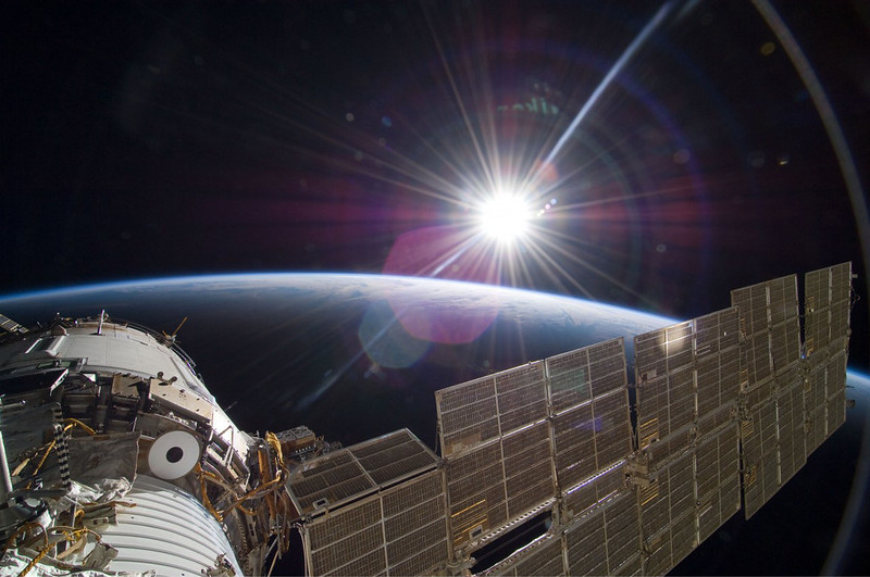 The sun rising over the International Space Station and Earth