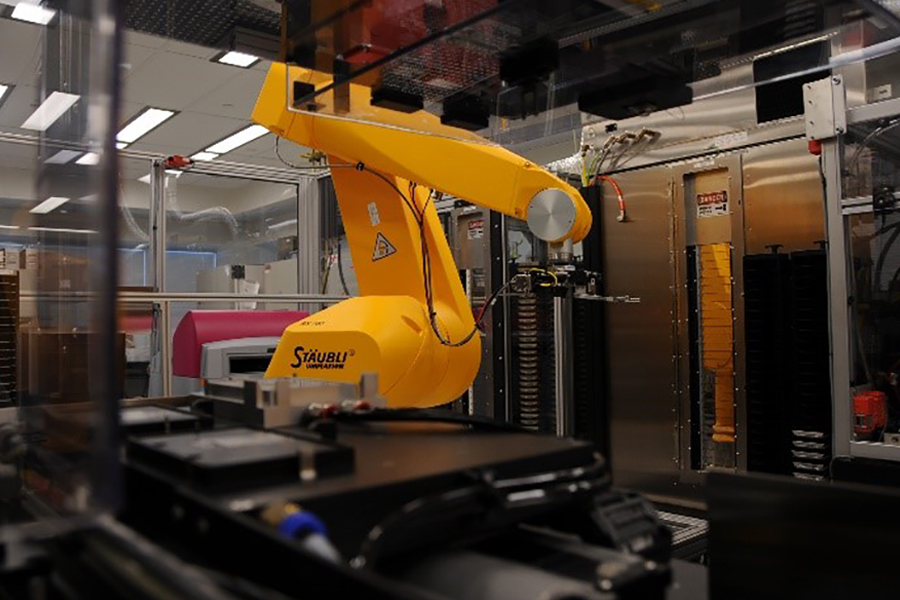 Robot retrieving compound plates from storage and transferring them to assay plates.