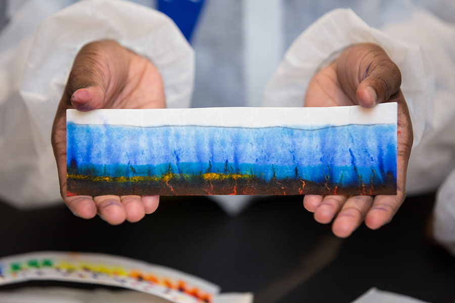 A student shows the result of his chromatography experiment during Frontiers in Science and Medicine Day 2018.