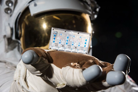 Astronaut holding a Tissue Chip