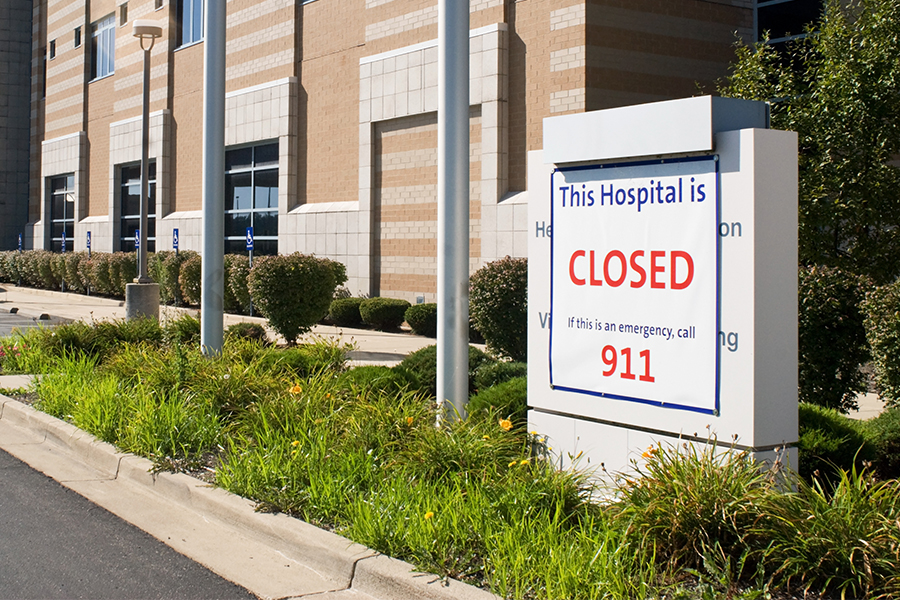 Large sign in front of a hospital that reads, “This Hospital is Closed. If this is an emergency, call 911.”