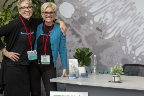 Two women standing in front of table