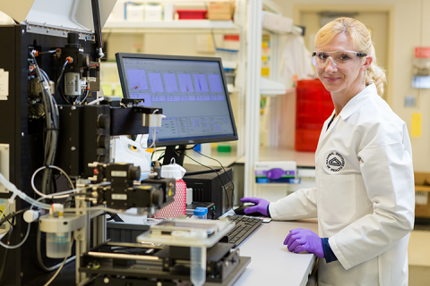 Researcher poses for an image while working in the lab