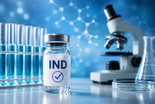 Glass vial labeled "IND" with a checkmark in the foreground with a microscope, petri dish and test tubes in a test tube rack in the background.